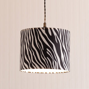 Lamp with zebra pattern shade on a striped wall background