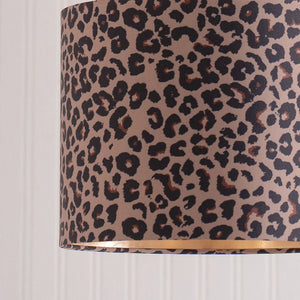 Leopard print lampshade with a gold rim on a white background