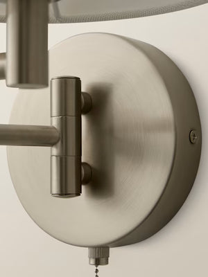 Close up of a matte chrome swing arm wall light