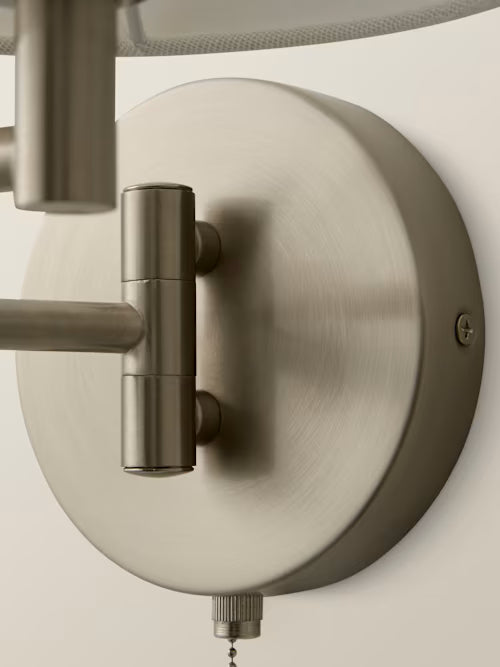 Close up of a matte chrome swing arm wall light