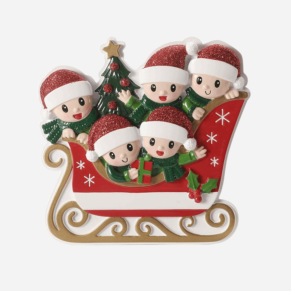 Christmas ornament with four children in Santa hats on a sleigh, featuring a tree and presents.