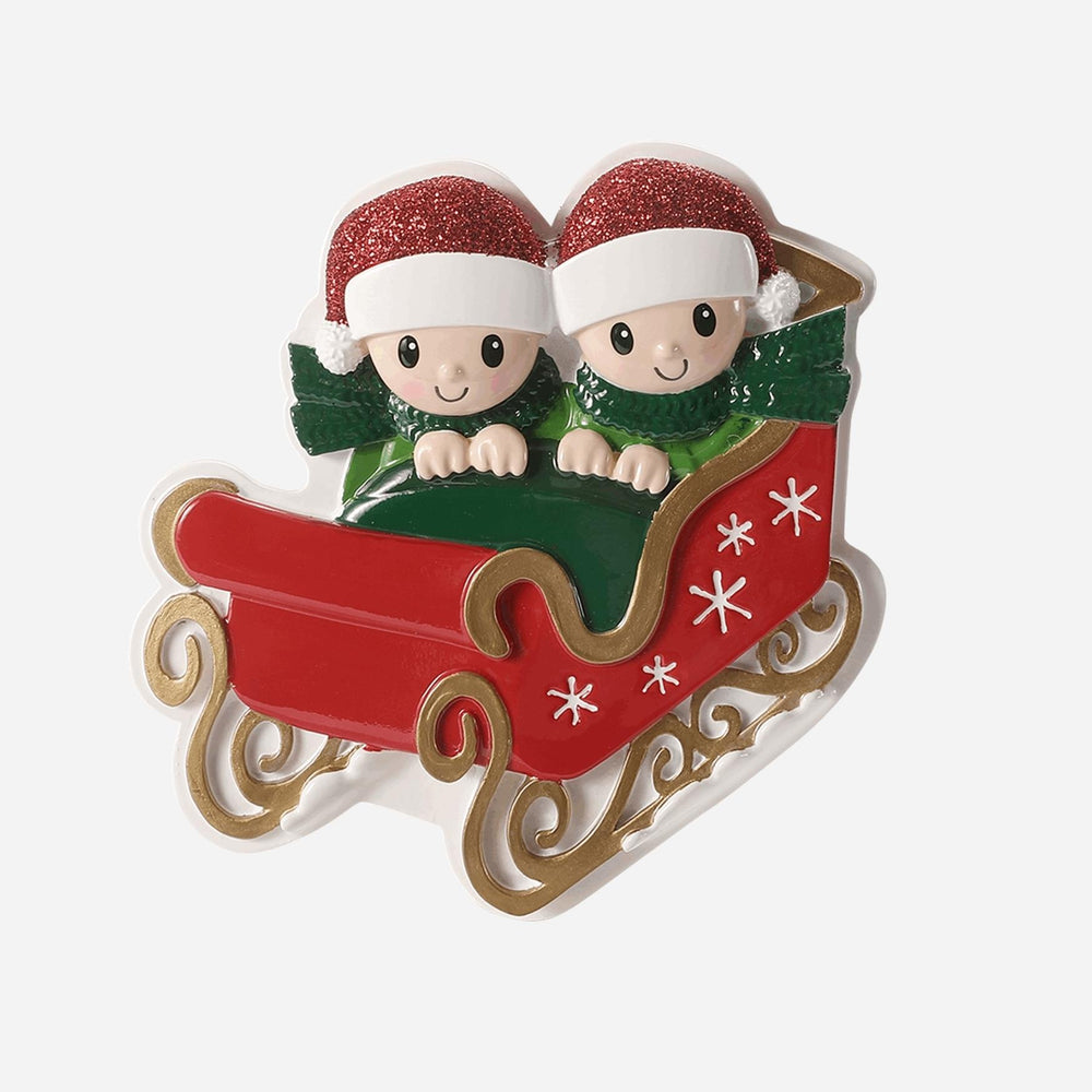 Christmas ornament with two elves in a sleigh on a white background