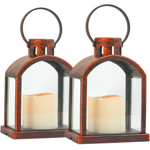 Two matching lanterns with a distressed bronze-brown metal frame, clear glass panels, and cream-colored flameless candles inside, shown on a white background.