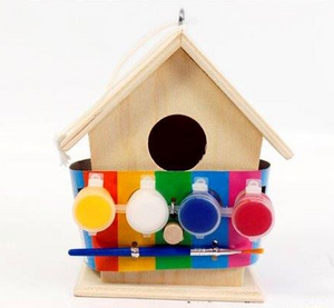 Wooden birdhouse with colorful paint containers on a white background