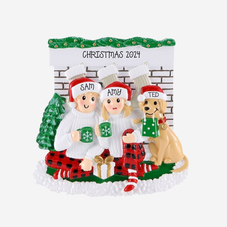 Personalized Christmas ornament with two people and a dog in festive attire against a brick wall background.
