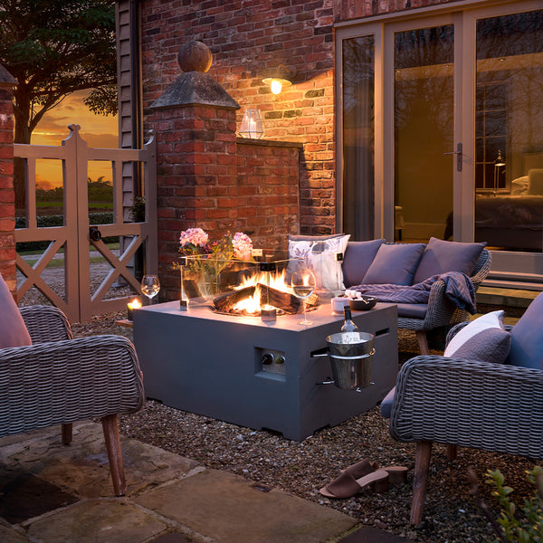 Outdoor patio with fire pit, chairs, and a cozy atmosphere.