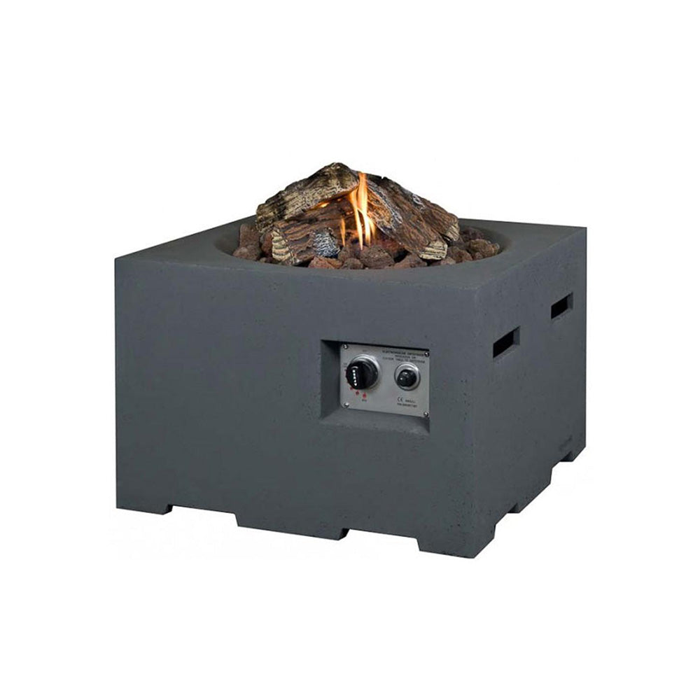 An outdoor fire pit with a grey composite body and a collection of ceramic logs and lava stones visible within it. The fire pit is set on a patio with greenery in the background and is accompanied by outdoor chairs.