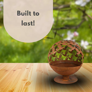Garden fire basket with laser-cut bird design.