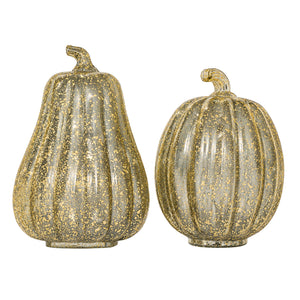 Two decorative glass pumpkins in metallic gold and silver tones, one elongated pear-shaped pumpkin and one round ribbed pumpkin, on a white background.