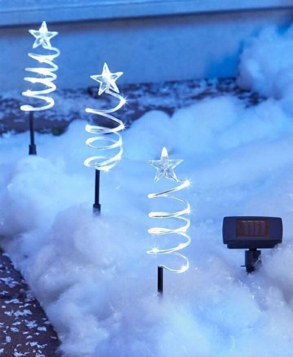 Four spiral tree lights positioned along garden pathway