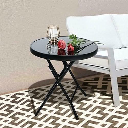 Black round folding side table with glass top