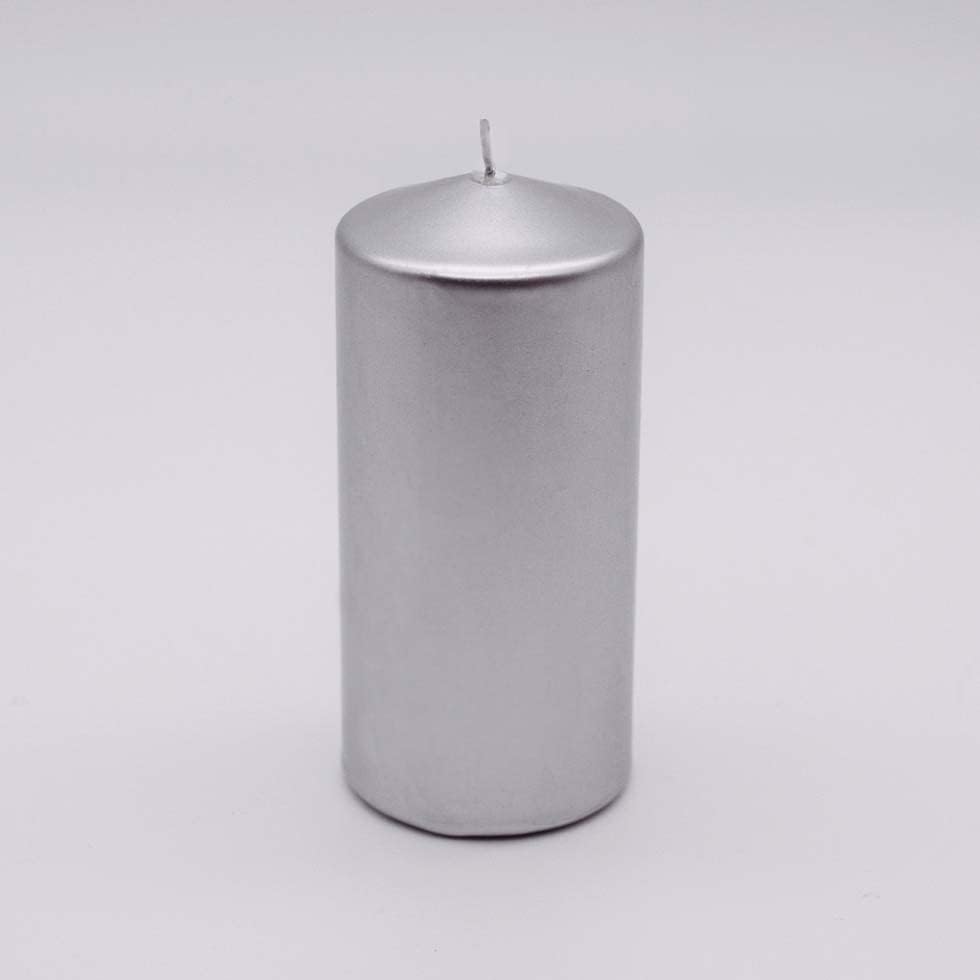 Silver candle with a flame, surrounded by Christmas decorations on a wooden surface.