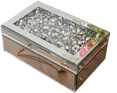 Decorative jewelry box with rings and a ribbon on a table with a blurred festive background