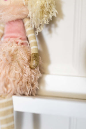 Seated pink fairy figure displayed in bedroom