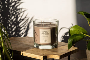 Three wick Dark Amber candle creating a warm glow