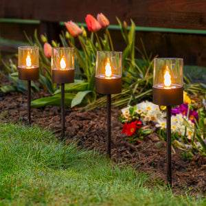 Four black solar ground spike pathway lights