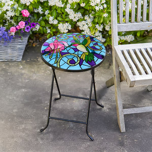 Colorful mosaic table with floral design on a patio.