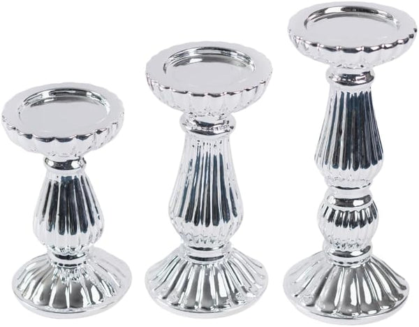 Three silver metallic candle holders of different sizes arranged side by side on a plain white background.