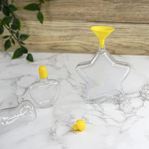 Clear glass bottles with yellow lids on a marble surface