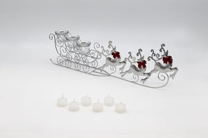 Decorative metal sleigh with reindeer and candles on a white background