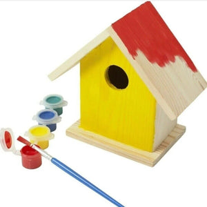 Wooden birdhouse with red roof, paintbrush, and paint colors on a white background