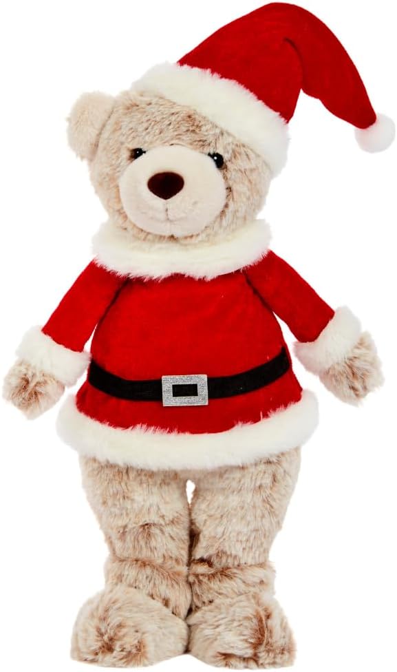 A large plush teddy bear dressed in a Santa Claus outfit, standing upright on a blue patterned rug.