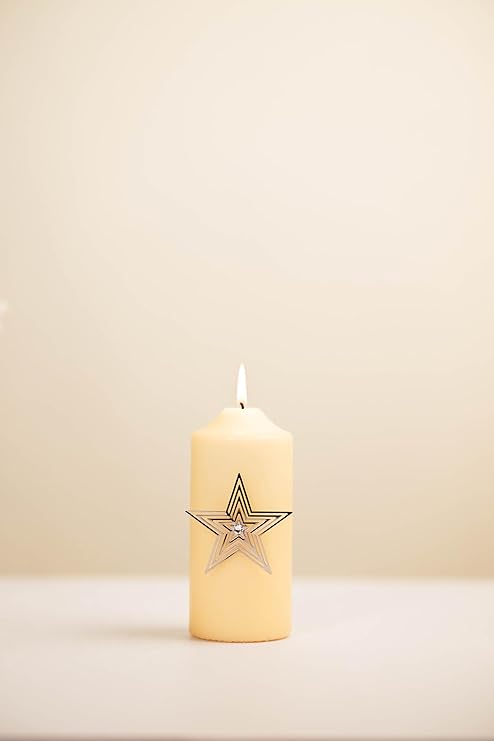 Beige candle with a star design on a beige background