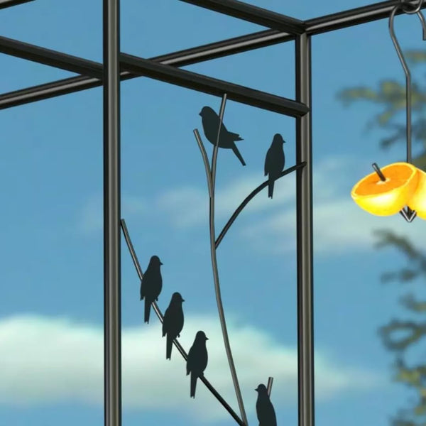 Decorative metal wall art with silhouettes of birds on a branch against a blue sky.