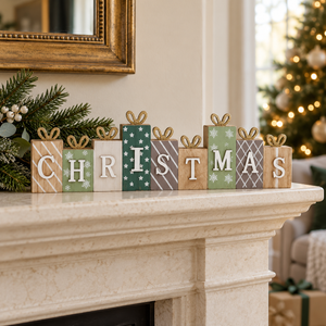 A set of seven wooden gift box letter signs spelling CHRISTMAS, decorated with various holiday patterns like stripes, snowflakes, and leaves, arranged on a cream marble mantelpiece in a decorated living room.