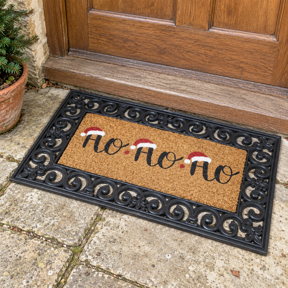 Ho Ho Ho Christmas coir doormat with an ornate black rubber surround outside a wooden front door.