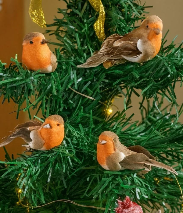 Four bird-shaped Christmas ornaments on a green tree with a blurred background