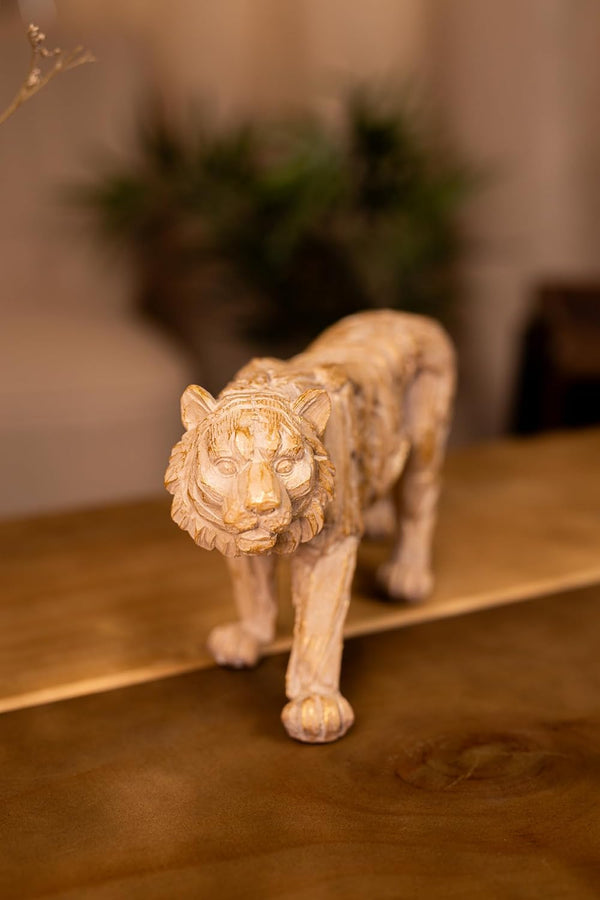 Statue of a tiger on a wooden surface with a blurred background