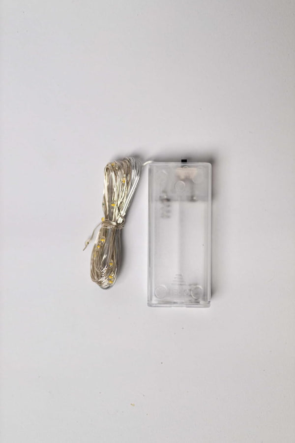 Clear glass rectangular object with a gold handle on a white background
