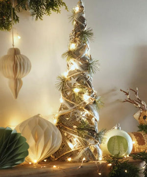 Decorative Christmas tree with lights and ornaments on a neutral background