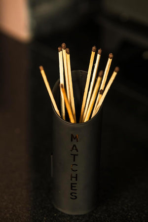 Black matches holder with matches on a dark background