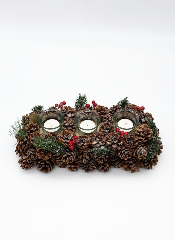 Decorative candle holder with pinecones and candles on a white background