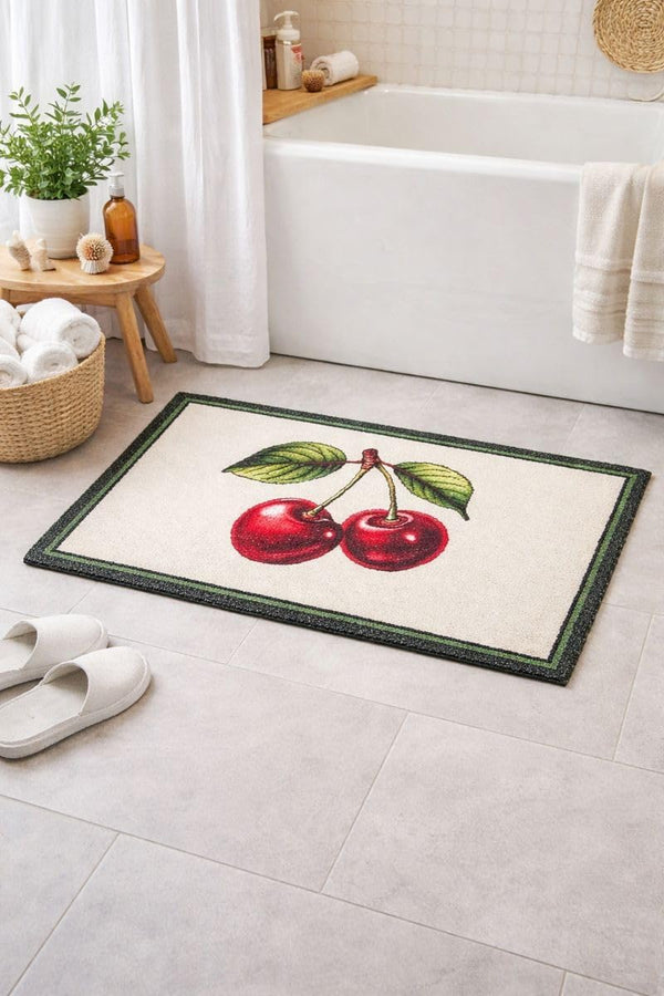 Bath mat with cherry design on a bathroom floor