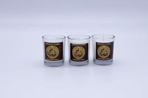 Three glass candles with a logo and text on a white background
