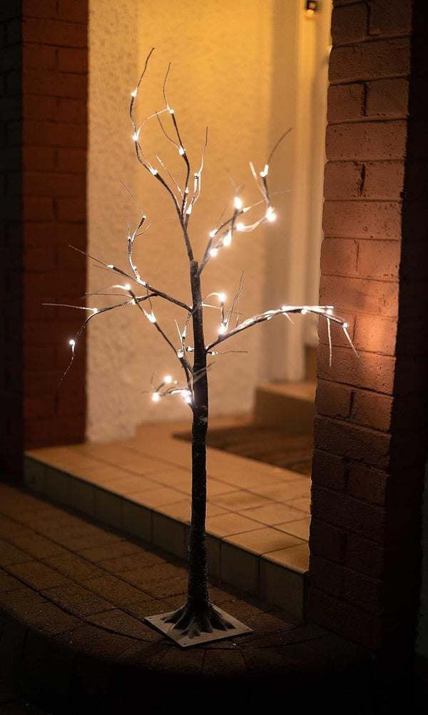 Decorative light tree with white lights on a brick wall background