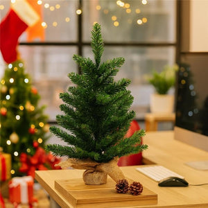 Small Christmas tree on a desk with festive decorations in the background