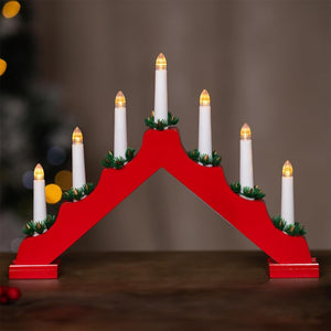 Red wooden Advent candle holder with white candles on a dark background