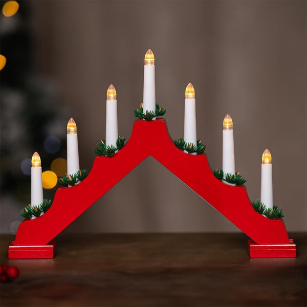Red wooden Advent candle holder with white candles on a dark background