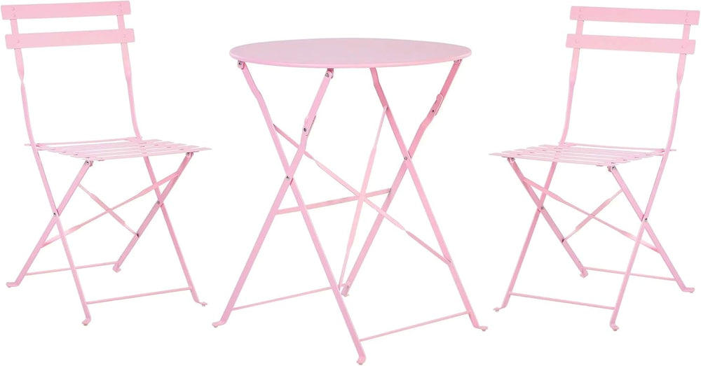 Pink metal table and chairs set on a garden with flowers and plants.