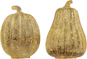 Two gold glittery pumpkins on a white background