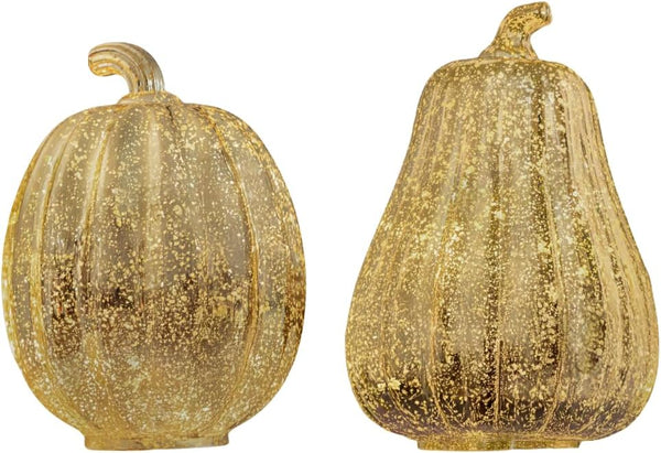 Two gold glittery pumpkins on a white background