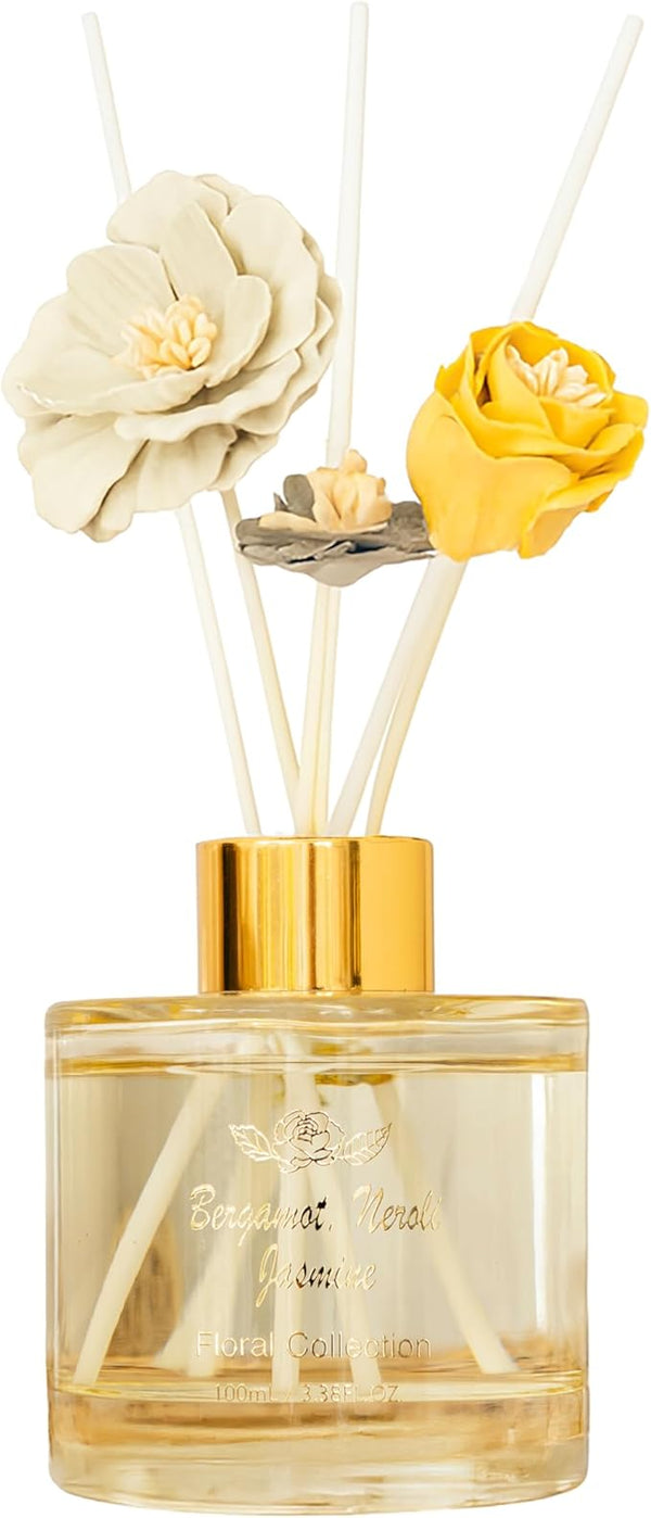 Decorative diffuser with floral elements and gold cap on a white background