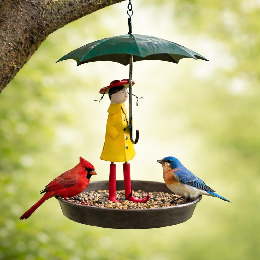 A hanging garden bird feeder designed as a young girl in a rain mac holding an umbrella, with a large tray at the base to catch seeds.