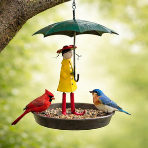 Decorative bird feeder with a figurine of a girl in a yellow raincoat holding an umbrella, surrounded by birds.