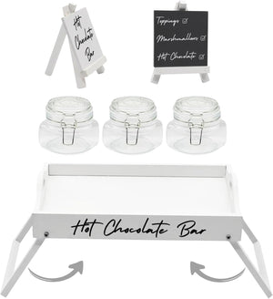 Hot chocolate bar setup with jars, a tray, and signs on a white background