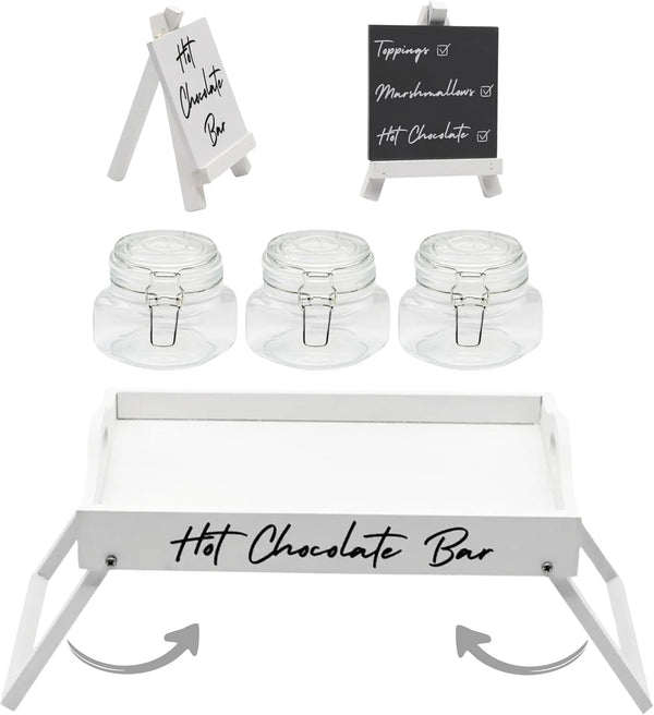 Hot chocolate bar setup with jars, a tray, and signs on a white background